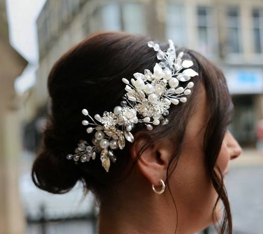 Bridal updo with a pearl and crystal accessory